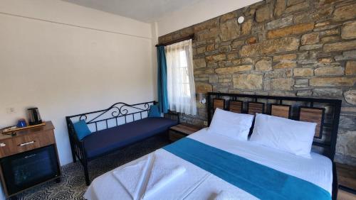 a bedroom with a bed and a stone wall at Bergüzar Hanım Konukevi in Gokceada Town
