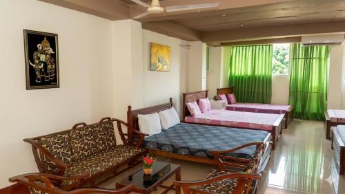 a room with a bed and a table and chairs at The Beehive in Bambalapitiya