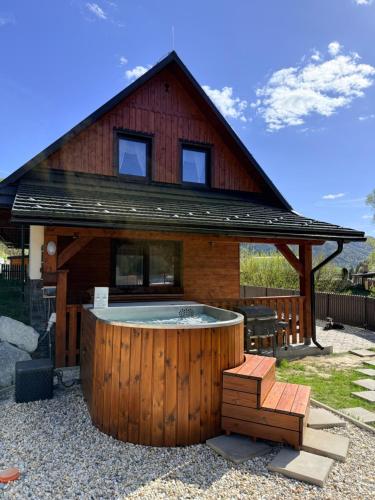 a house with a hot tub in front of it at Chata do Zlatneho in Terchová