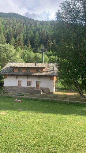 ein Gebäude inmitten eines Grasfeldes in der Unterkunft Chalet Angelo in Ponte di Legno
