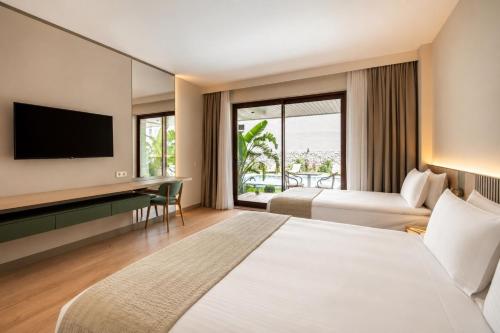a hotel room with two beds and a television at Arkk Rooms in Antalya