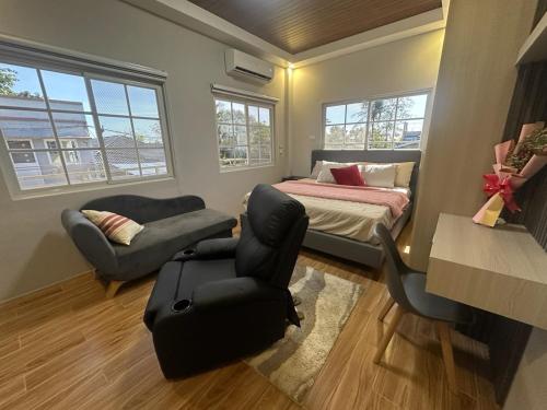 a bedroom with a bed and a couch and a chair at Casa Gutierrez in Lingayen