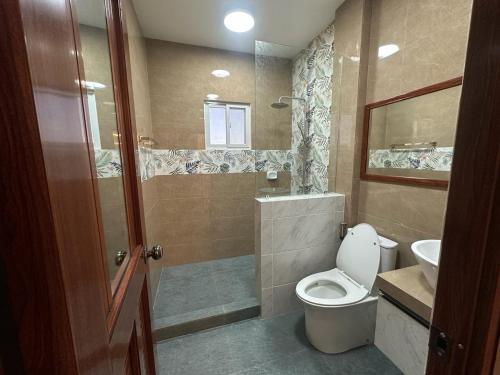 a bathroom with a toilet and a sink and a shower at Casa Gutierrez in Lingayen
