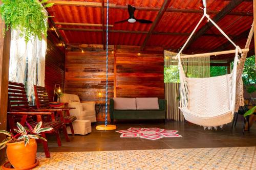 a porch with a hammock and a table and chairs at Espaço Aricá in Chapada dos Guimarães