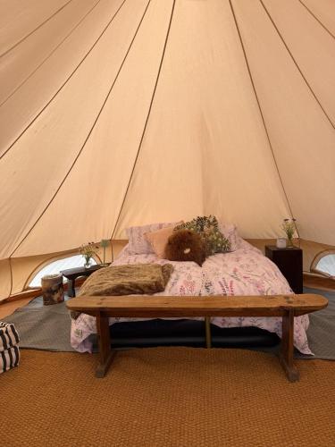 a bed in a tent with a teddy bear on it at Apuldram Roses in Appledram