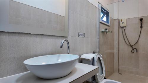 a bathroom with a white sink and a toilet at Sanfhan Resort-SHA Plus in Khao Chai Son