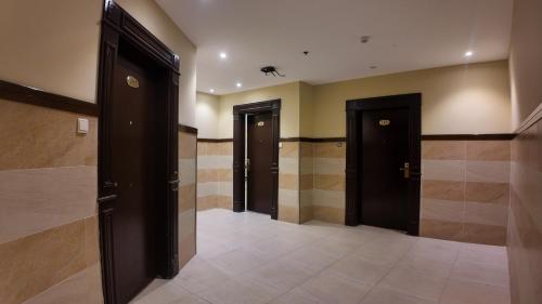 a hallway with three doors in a building at أجنادين للشقق المخدومة in Riyadh