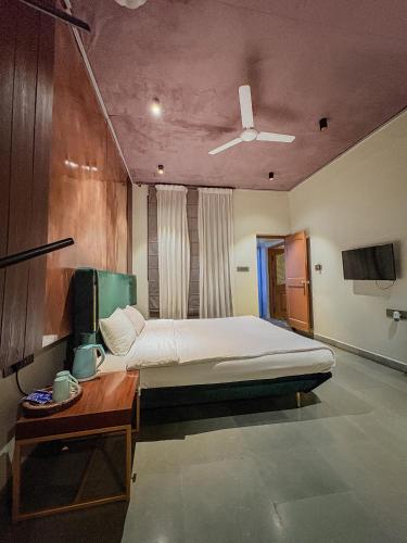 a bedroom with a bed and a table and a ceiling at Giovanni House in Bhopal