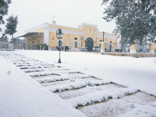 a snow covered garden in front of a building at Tenuta Orsanese in Ginosa Marina