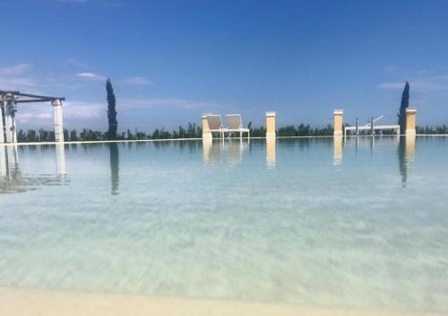 a large body of water with two chairs in it at Tenuta Orsanese in Ginosa Marina