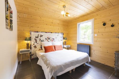 a bedroom with a bed in a wooden room at chalets les biches in Gérardmer