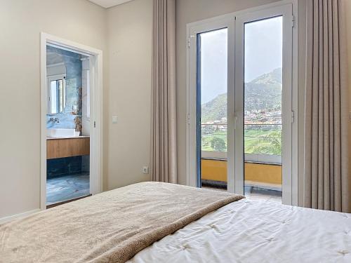 a bedroom with a bed and a large window at Recanto do Sol by Atlantic Holiday in Caniçal