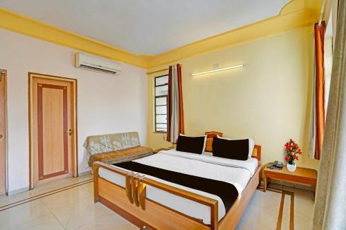 a bedroom with a bed and a couch in it at Collection O Dandiya Bazar Formerly Vrundavan Residency in Vadodara
