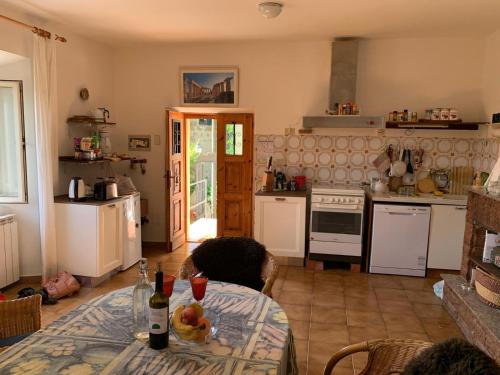 a kitchen with a table with a bottle of wine at Casa Belvedere in Mazzano Romano