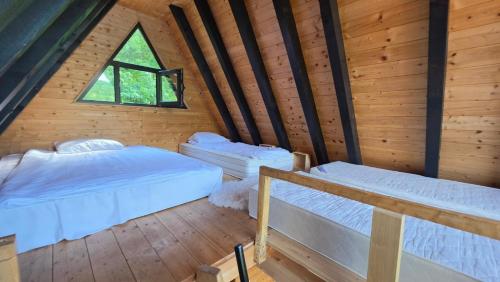a room with two beds and a window in a cabin at Omorika Perućac Splav in Gaočići
