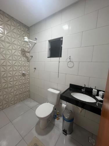 a bathroom with a toilet and a sink at Aconchego e conforto in Bom Jesus da Lapa