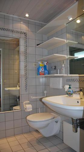 a bathroom with a sink and a toilet and a mirror at Haus Nautic Whg 810 Seesicht in Cuxhaven