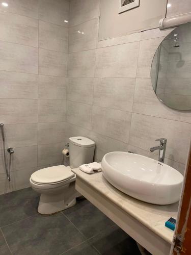 a bathroom with a toilet and a sink and a mirror at Hunza Embassy Hotel by Zeez in Karimabad Hunza
