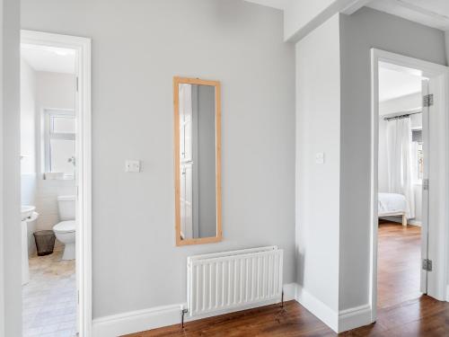 a bathroom with white walls and a mirror on a wall at Paddy Carrolls Cottage in Ballyconneely