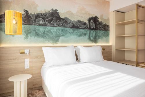 a bedroom with a bed and a painting on the wall at Parkest Hôtel & Spa in Genas