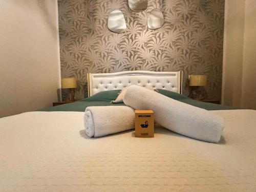 a bed with two towels and a box on it at Le Régent - Perpignan city center in Perpignan