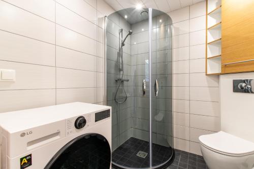 a washing machine in a bathroom with a shower at TEN Apartments - Kuressaare in Kuressaare