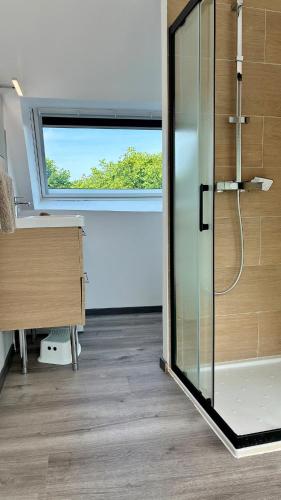 a glass shower in a bathroom with a window at Ty Neel - central - Wi-Fi in Crozon