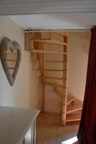 a spiral staircase in a room with a heart on the wall at Apartment the Haven in Cucugnan