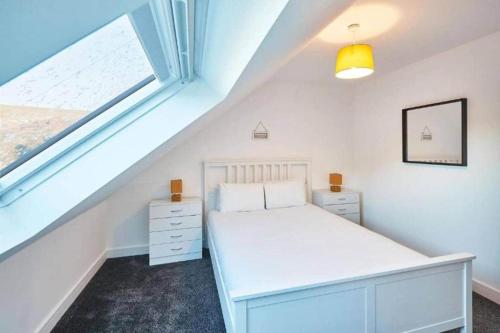 a bedroom with a white bed and a window at Skinningrove Beach House 1 in Skinningrove