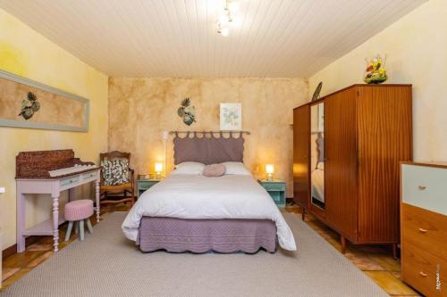 a bedroom with a bed and a dresser and a desk at L'instant ROSE - Escapade Champêtre in Grazac