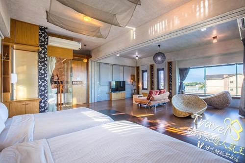 a bedroom with two beds and a living room at 建築師湧泉泡湯會館 in Dongshan