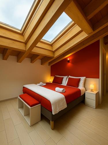 a bedroom with a large bed with a skylight at ValtellinaHome in Villa di Tirano