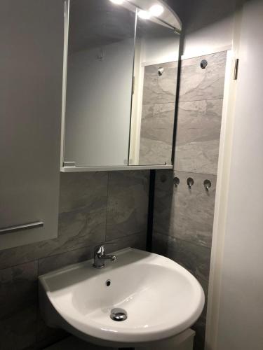 a bathroom with a white sink and a cabinet at FEWO Priel Watt Nr.2 in Cuxhaven