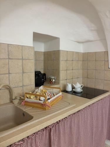 a kitchen with a counter top with a sink and a counter sidx sidx at Trulli Vulés in Ostuni