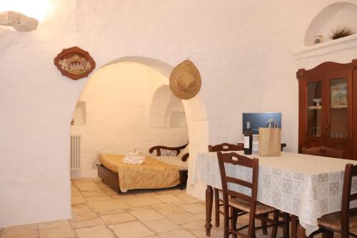 a room with a bed and a table and chairs at Trulli Vulés in Ostuni