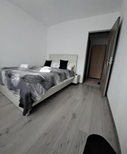 a bedroom with a bed and a wooden floor at Montain apartament in Brezoi