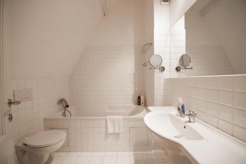łazienka z umywalką, toaletą i wanną w obiekcie Eclectic Loft Royal Way w Pradze