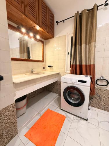 a bathroom with a washing machine and a sink at C2 Résidence CHATT in Tétouan