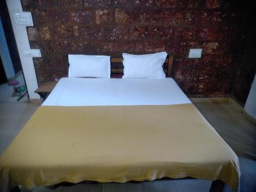 a large bed in a room with a brick wall at Casa Viora in Calangute