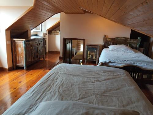 a bedroom with two beds and a wooden floor at Vivenda Por do Sol in Ponta do Sol