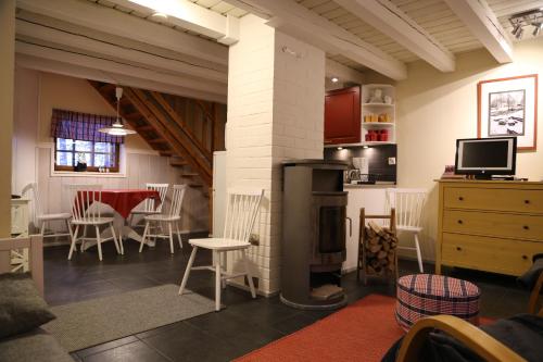 salon z kominkiem, stołem i krzesłami w obiekcie Linkkumylly Cottages w mieście Mäntyharju