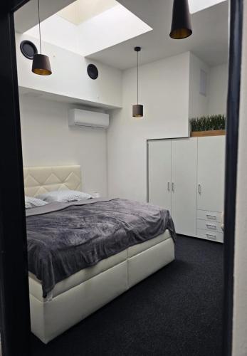 a bedroom with a large bed and white walls at Centrál apartmán in Zvolen