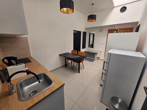 a kitchen with a sink and a refrigerator at Centrál apartmán in Zvolen