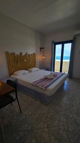 a bedroom with a bed with a view of the ocean at Mike's Beach Apartments & Studios in Hersonissos