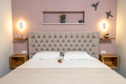 a bedroom with a large white bed with flowers on it at אצל ירדנה- מתחם אירוח כפרי ענק למשפחות in Sifsufa