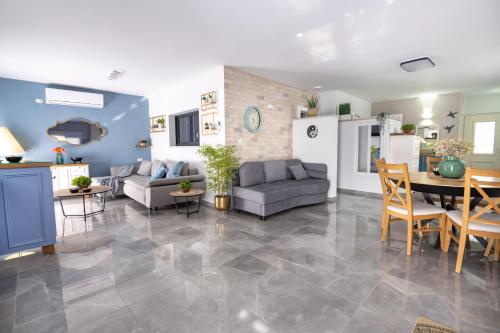 a living room with a couch and a table at אצל ירדנה- מתחם אירוח כפרי ענק למשפחות in Sifsufa