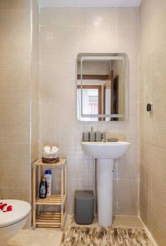 a bathroom with a sink and a mirror and a toilet at Le Balcon Bohème des Golfs in Marrakesh