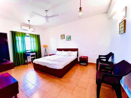 a bedroom with a bed and a chair in it at Beachside Studio Apartment Baga in Baga