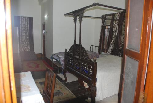 a bedroom with two canopy beds and a table at Hilltop Lodge in Guwahati
