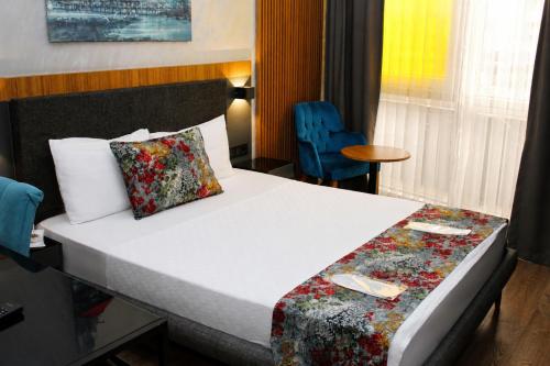 a hotel room with a bed and a blue chair at Istanbul Fair Hotel in Istanbul